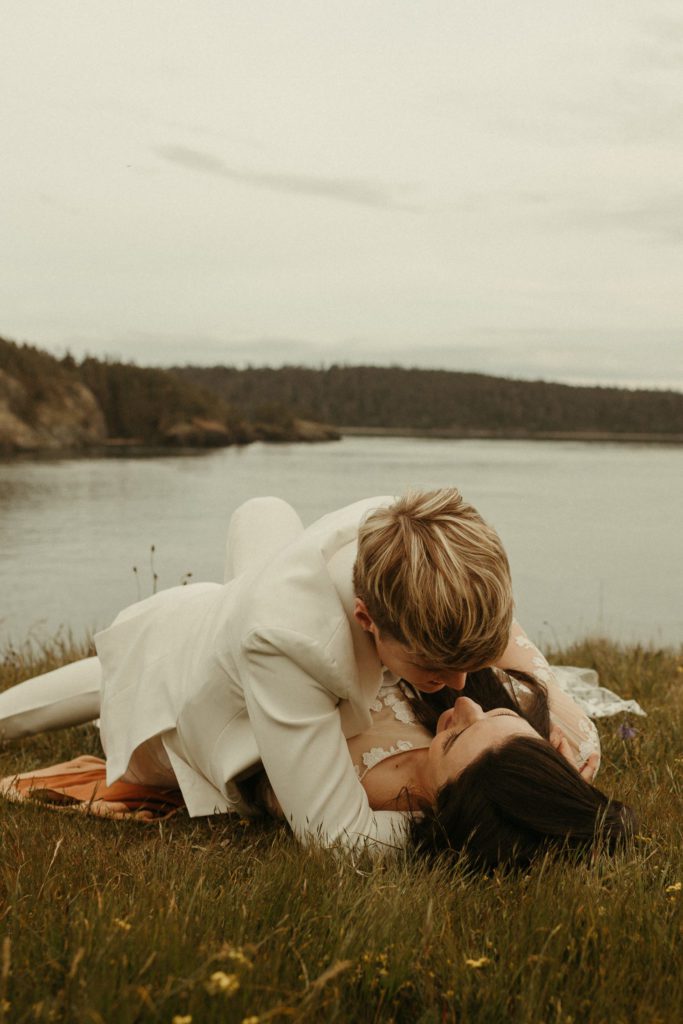 A couple laying in the grass together after their vow renewal at Deception Pass.